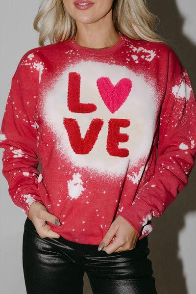 a woman wearing a red sweater with the word love painted on it