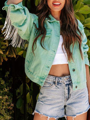 a woman wearing a green jacket and denim shorts