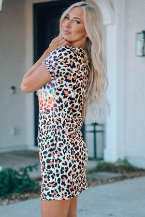 a woman standing on a sidewalk wearing a leopard print dress