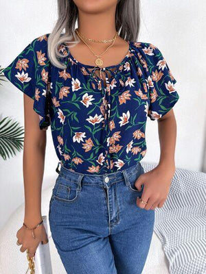 a woman with grey hair wearing a floral top