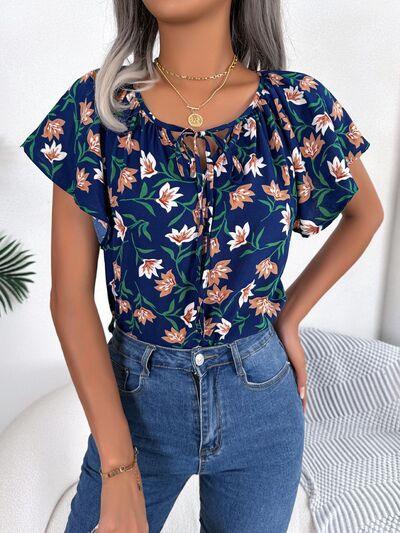 a woman with grey hair wearing a floral top