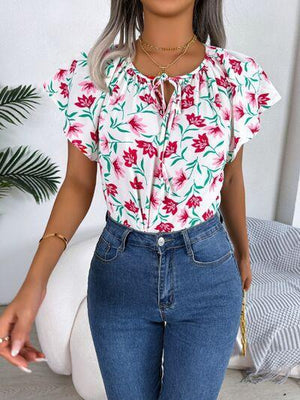 a woman wearing a floral shirt and jeans