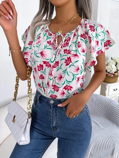 a woman with grey hair wearing jeans and a floral top