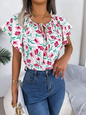 a woman wearing a floral blouse and jeans