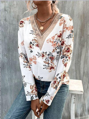 a woman sitting on a bench wearing a white blouse and jeans