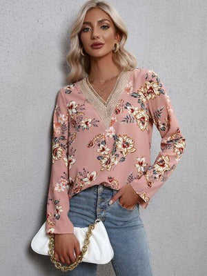 a woman wearing a pink floral top and jeans