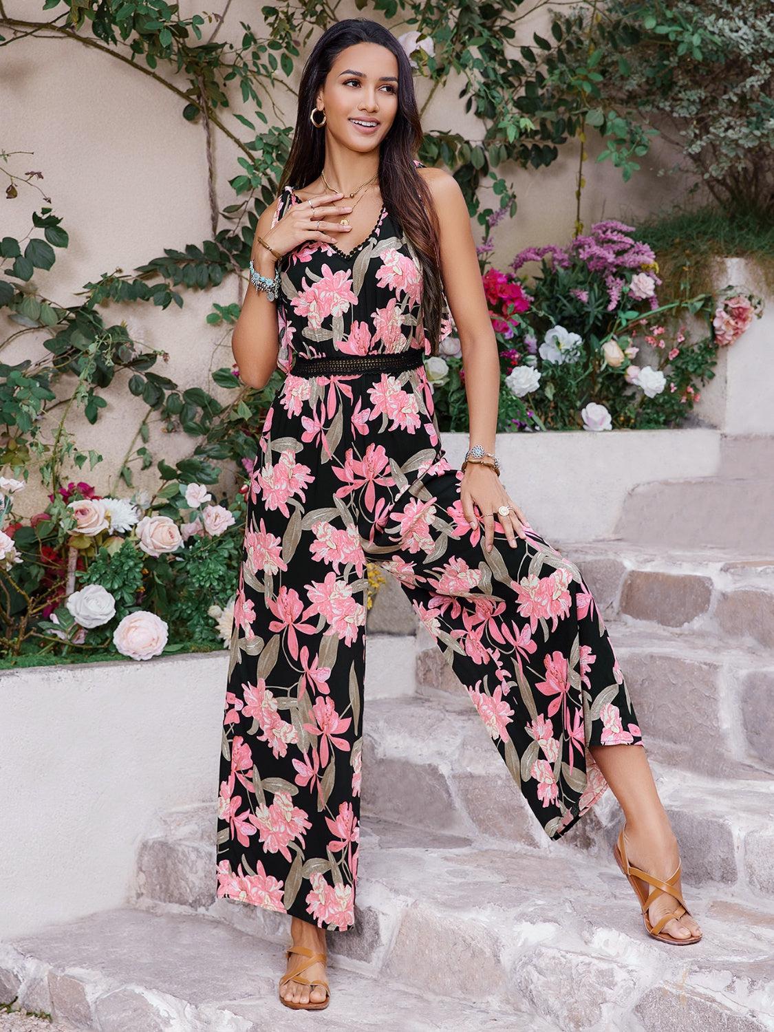 a woman in a black and pink floral print jumpsuit