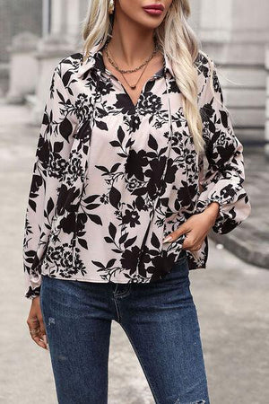 a woman wearing a black and white floral shirt