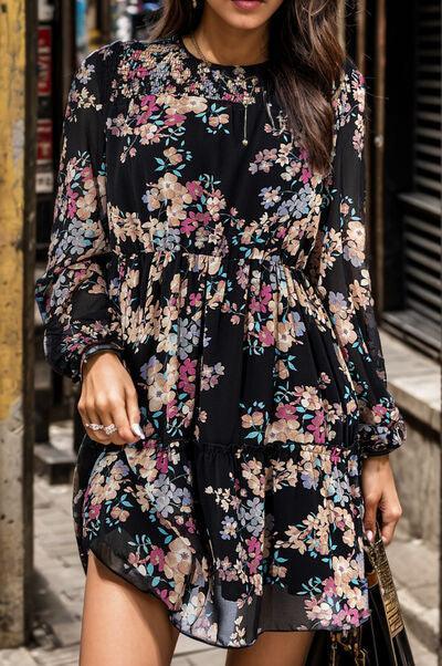 a woman walking down a street wearing a black floral dress