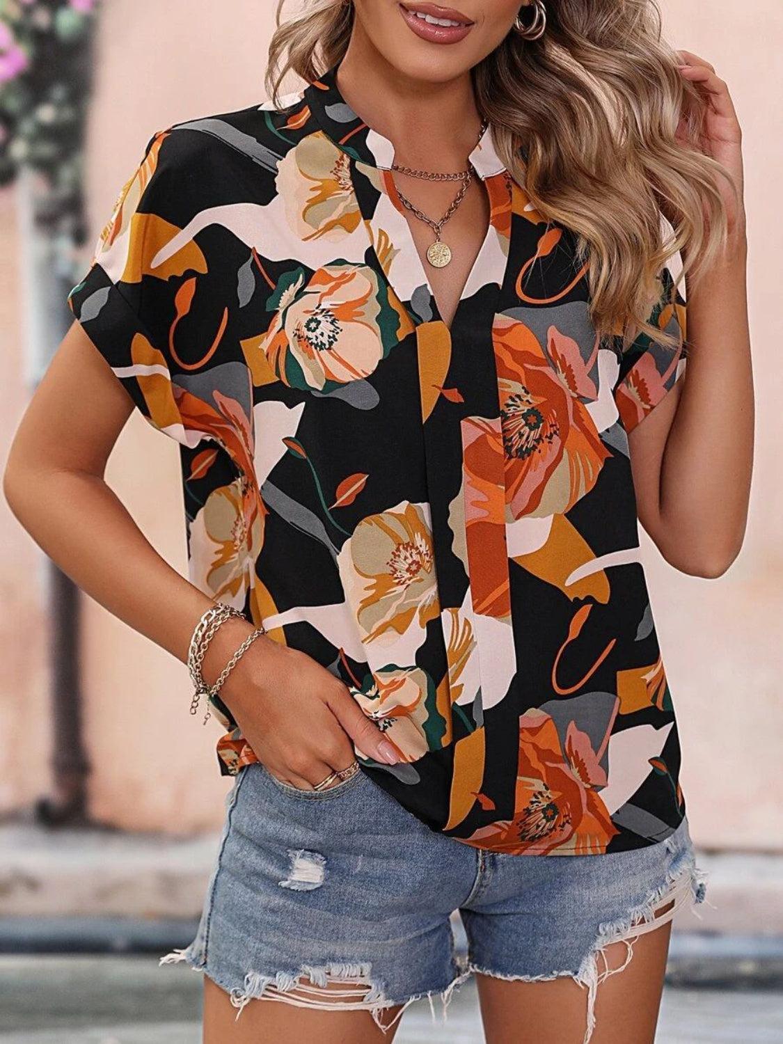 a woman wearing a floral shirt and ripped shorts