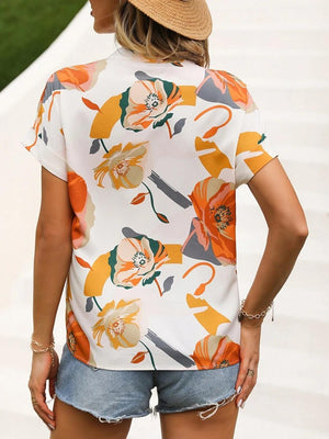 a woman wearing a hat and a floral shirt