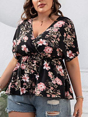 a woman wearing a floral top and ripped shorts