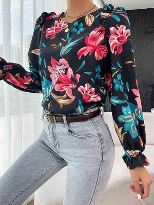 a woman wearing a floral blouse and jeans