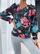 a woman wearing a floral blouse and jeans