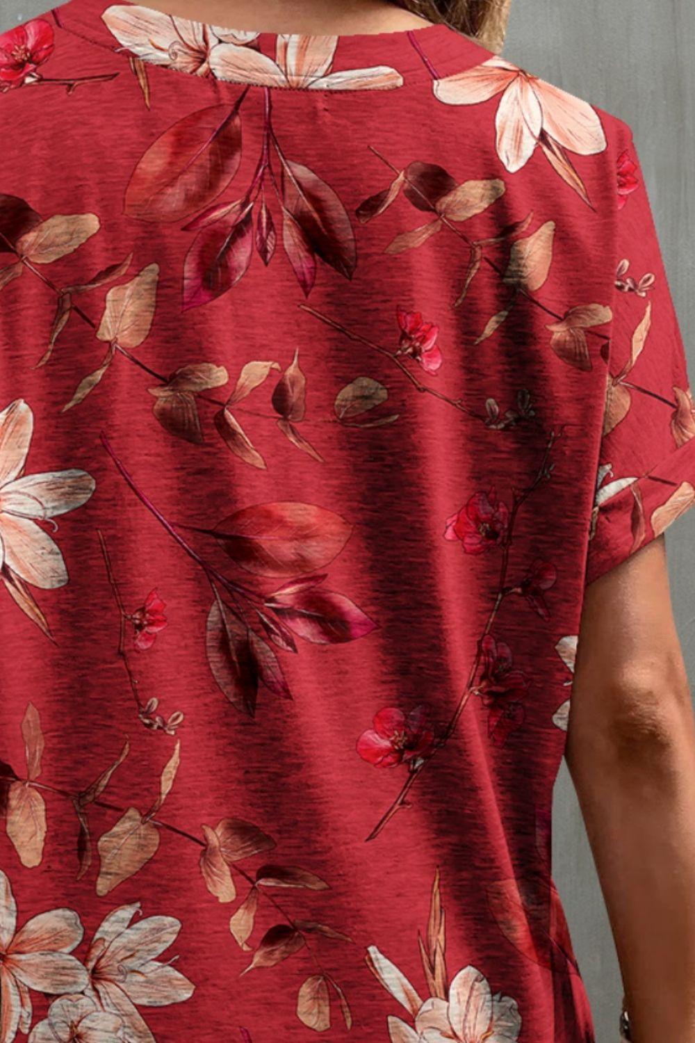 a woman wearing a red top with flowers on it