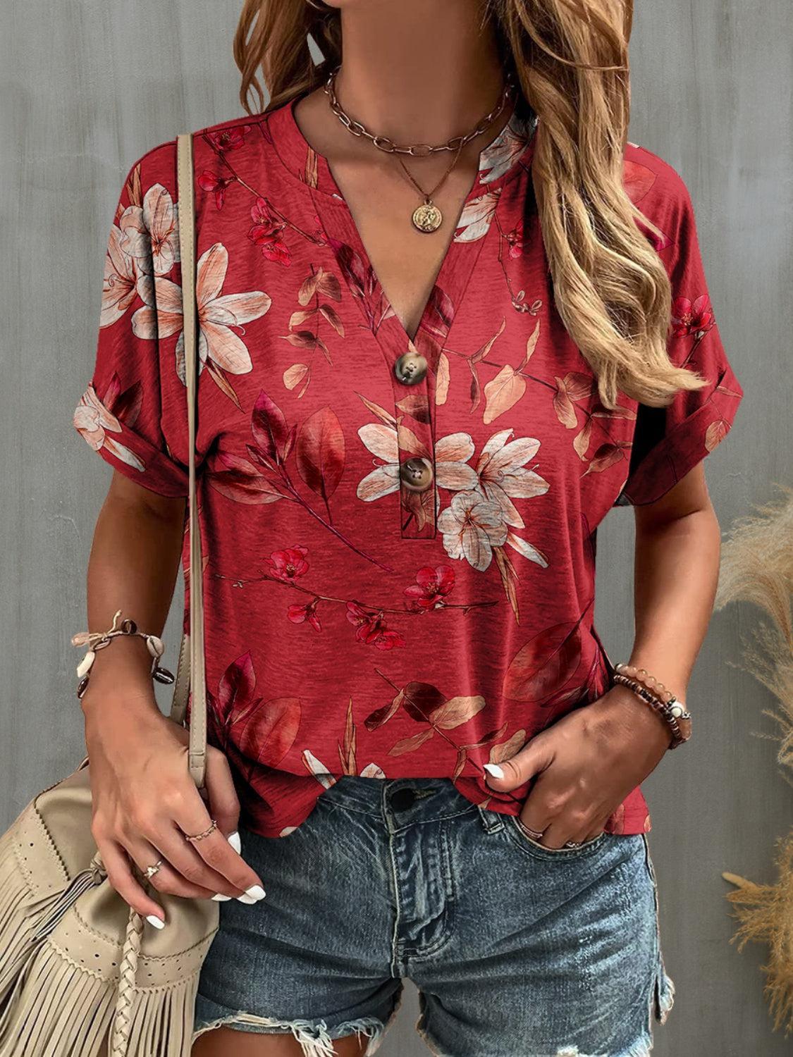 a woman wearing a red floral shirt and ripped shorts