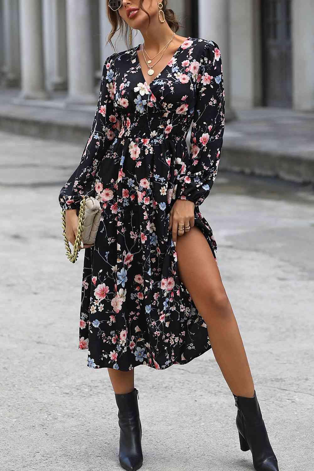 a woman wearing a black floral dress and black cowboy boots