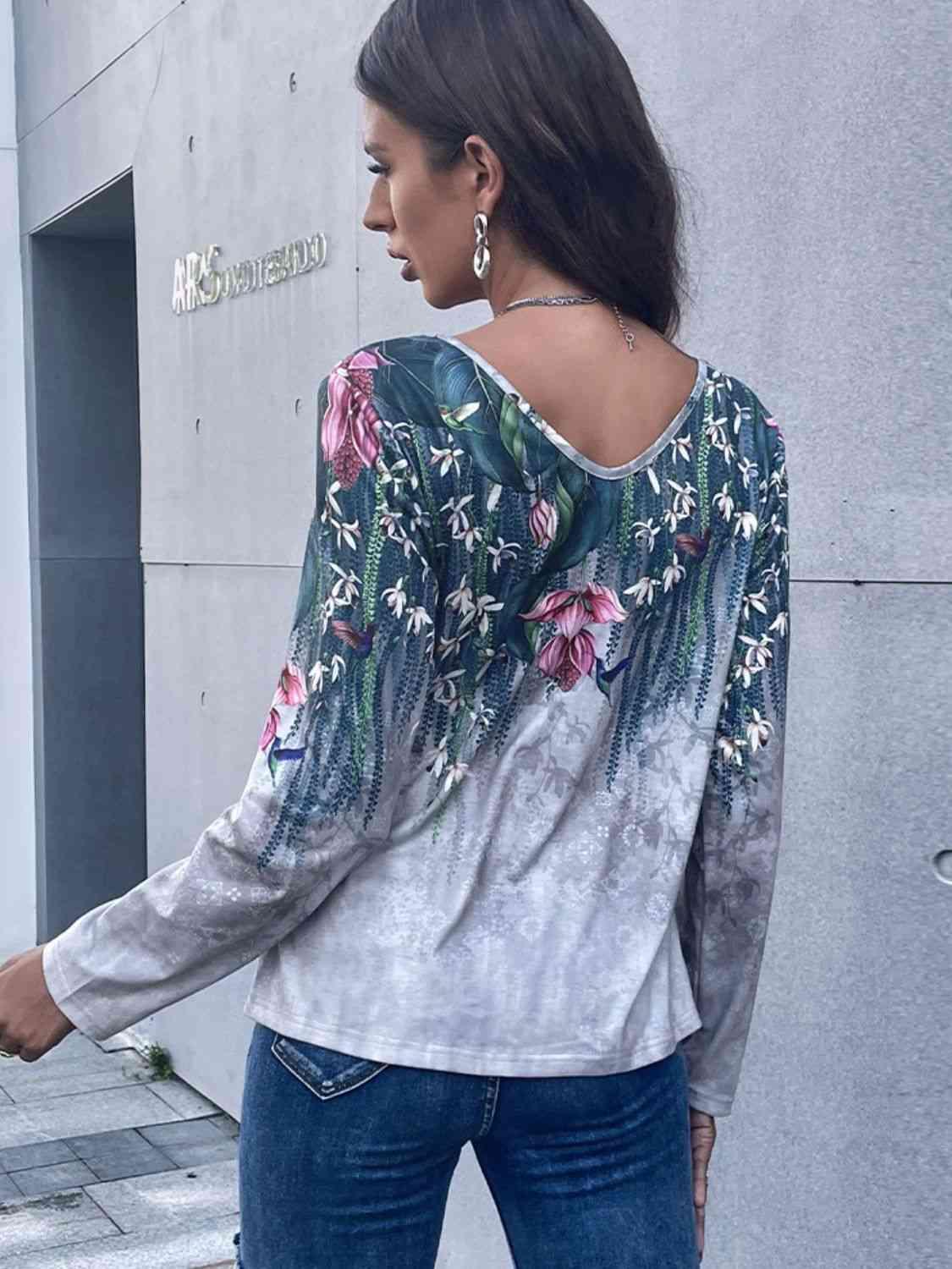 a woman wearing jeans and a top with flowers on it