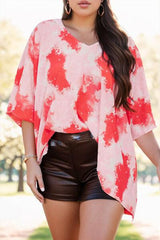 a woman wearing a red and white top and black shorts