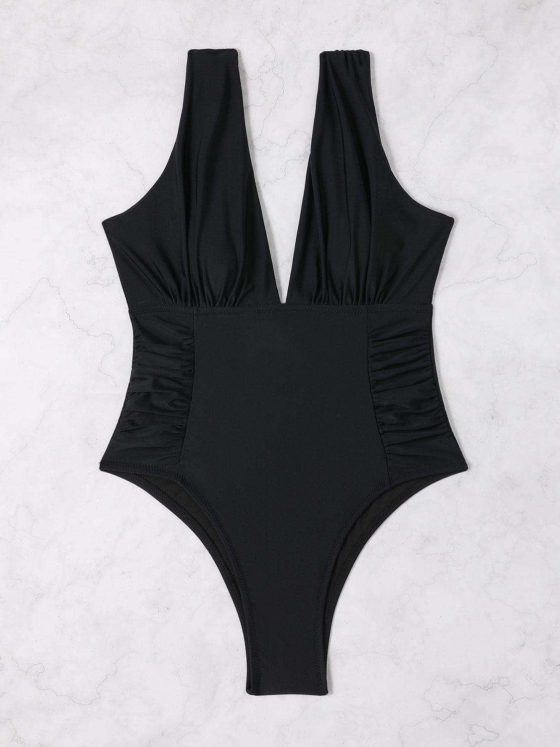 a black one piece swimsuit on a marble background