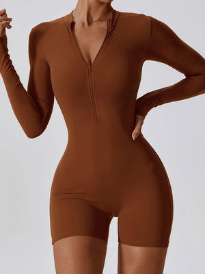 a woman in a brown bodysuit posing for the camera