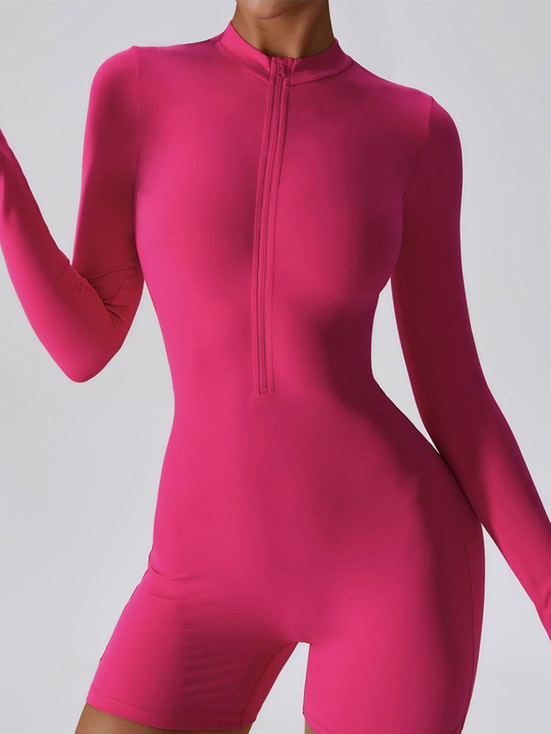 a woman in a pink bodysuit holding a cell phone