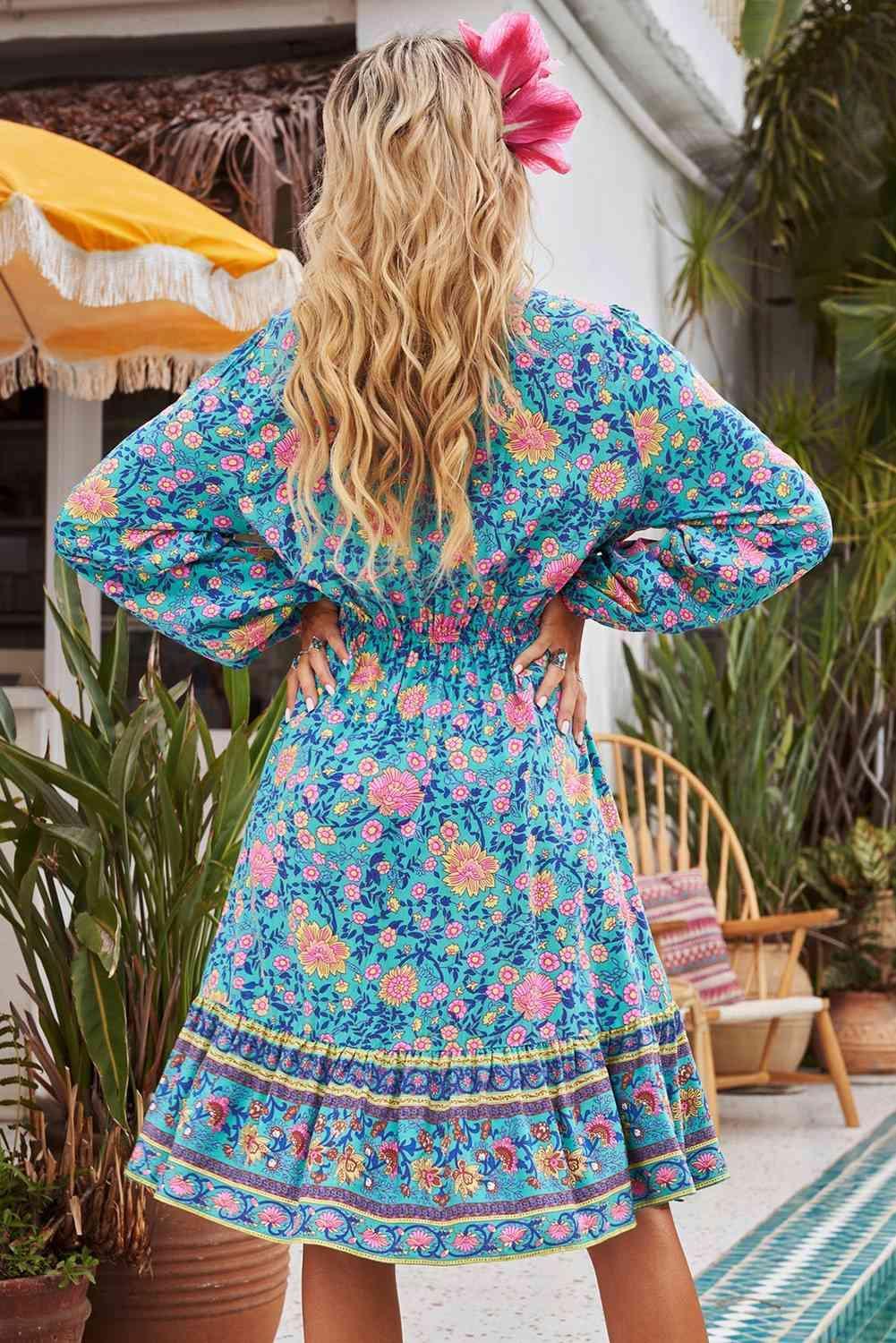 a woman standing in front of a pool wearing a blue floral dress