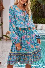 a woman standing in front of a pool wearing a blue floral dress