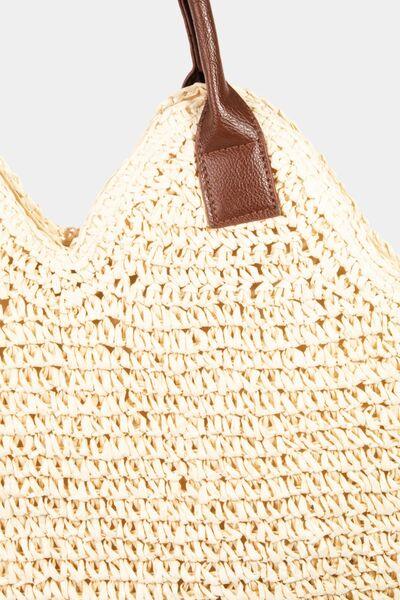 a crocheted straw bag with a brown leather handle