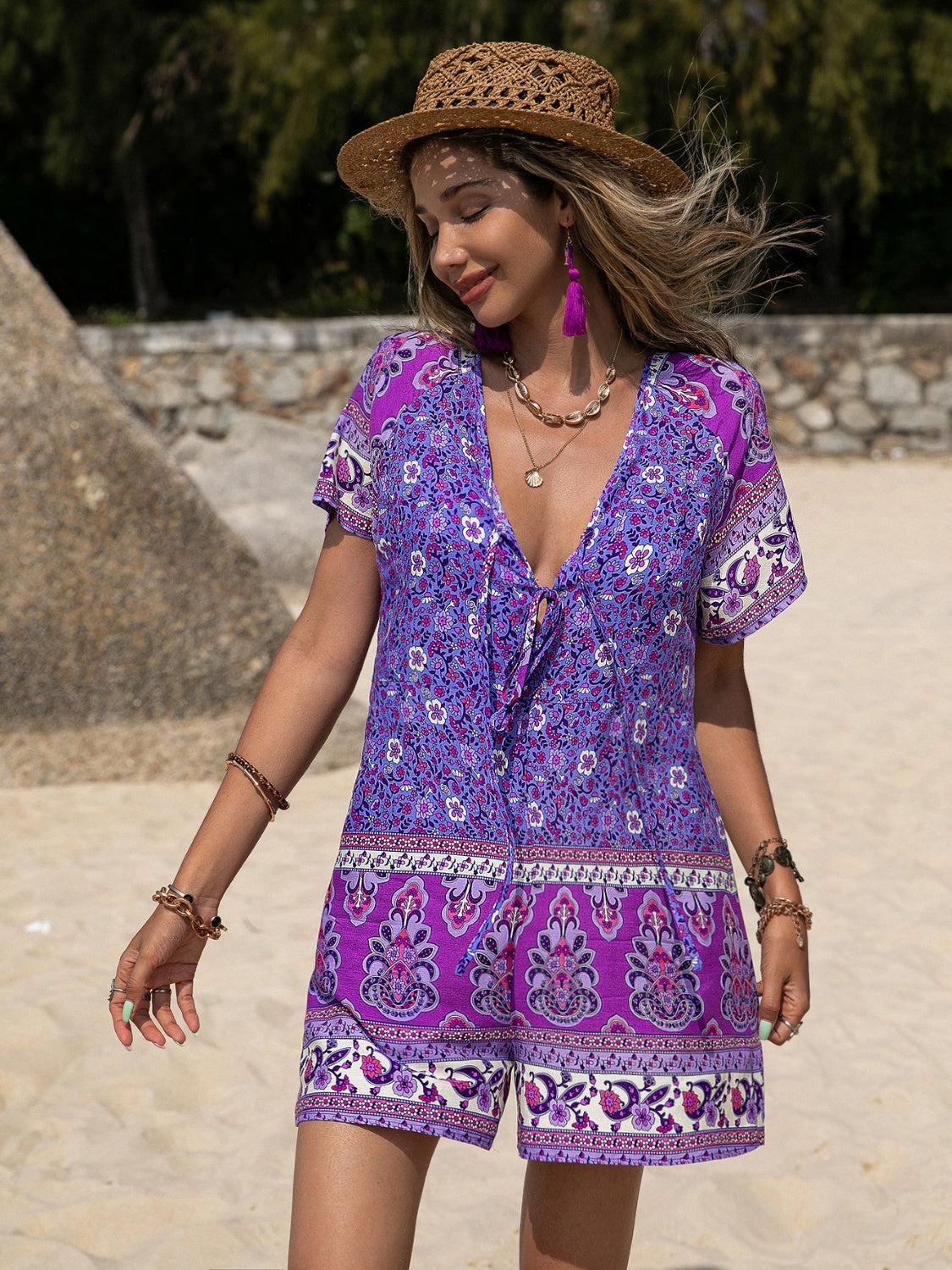 a woman in a purple dress and hat on a beach