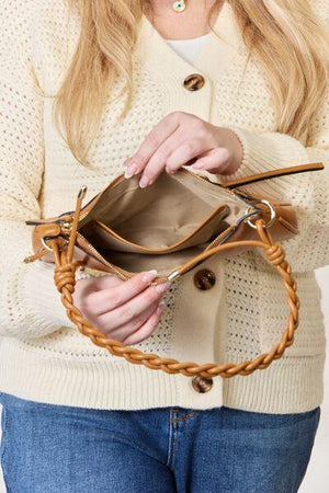 a woman holding a brown purse in her hands