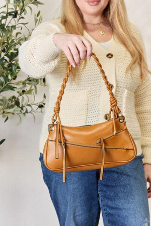 a woman is holding a brown purse