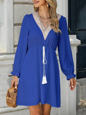a woman wearing a blue dress with a white tassel