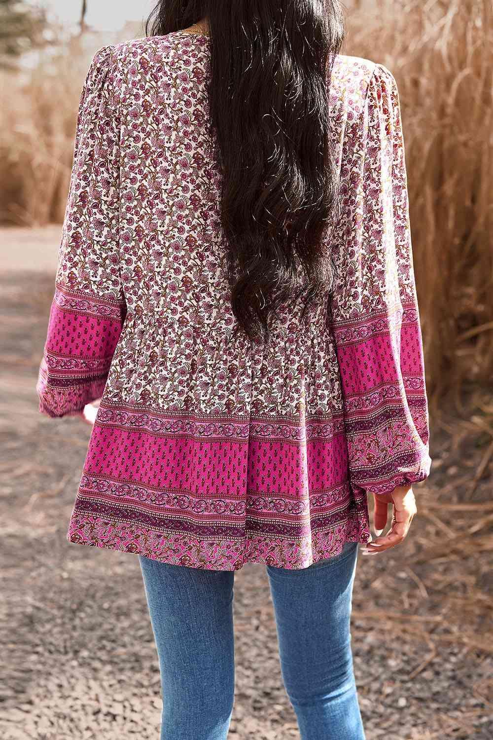 a woman with long black hair wearing a pink top