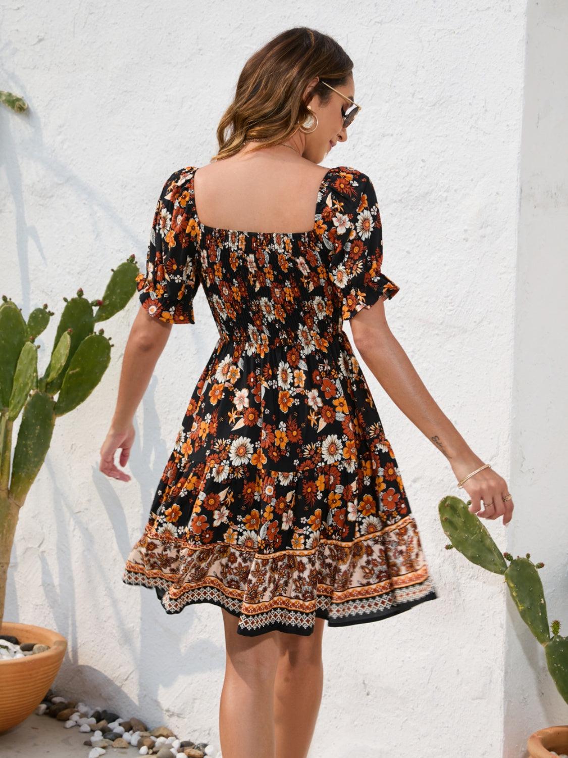 a woman in a black and orange floral print dress