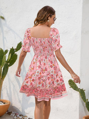 a woman in a pink dress is standing near a cactus