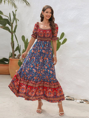 a woman in a long dress standing in front of a plant