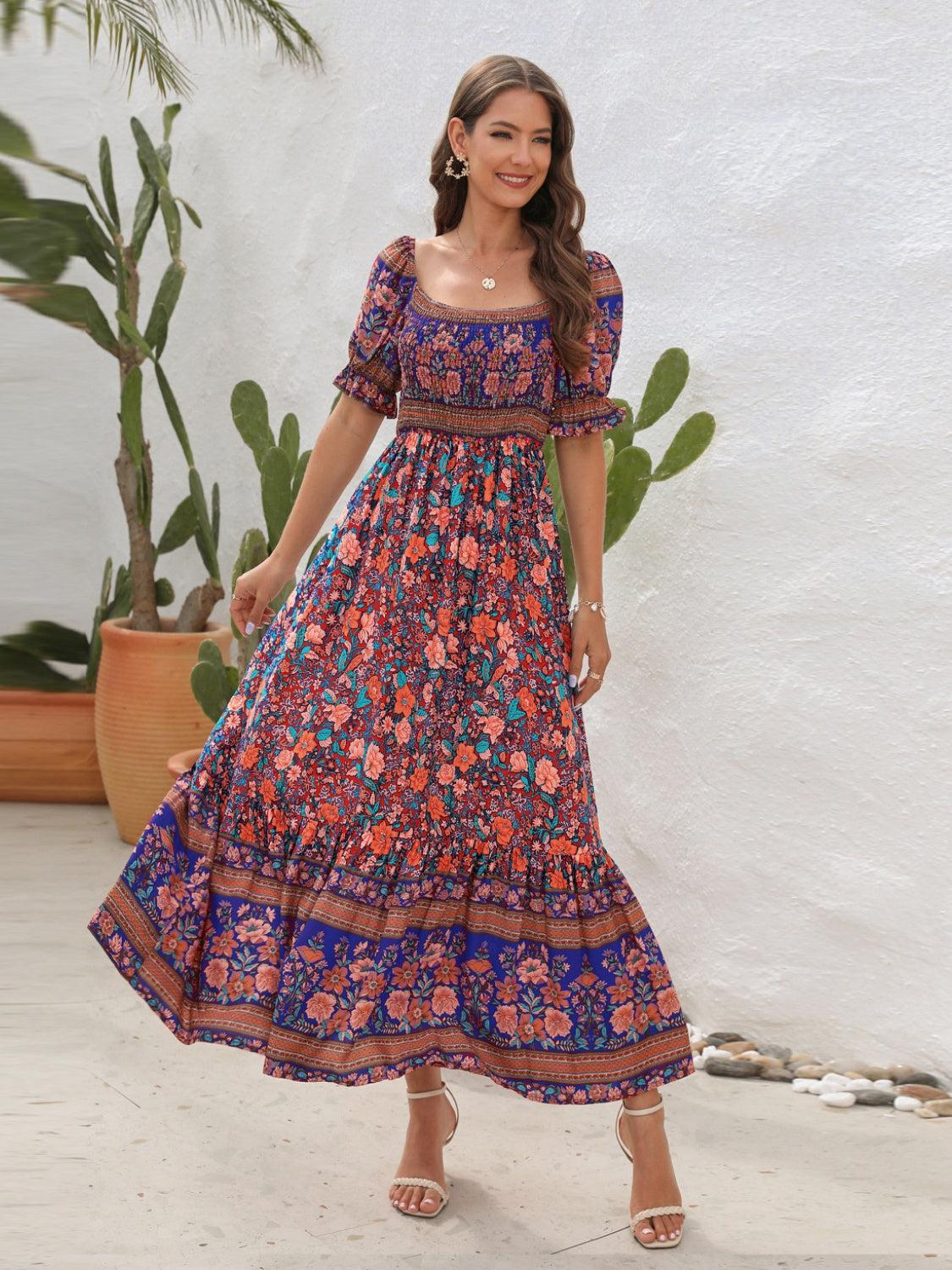 a woman in a long dress standing in front of a plant