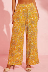 a woman wearing a yellow floral print pants