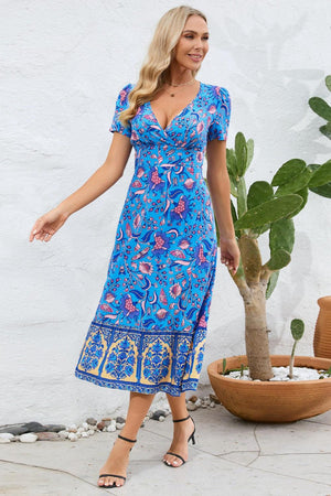 a woman in a blue dress standing next to a potted plant