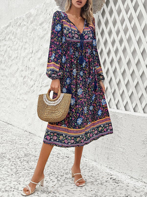 a woman in a floral print dress holding a straw bag