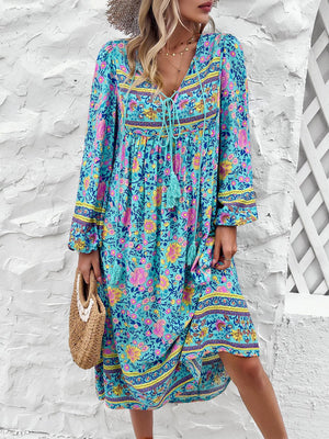 a woman wearing a blue floral dress and a straw hat