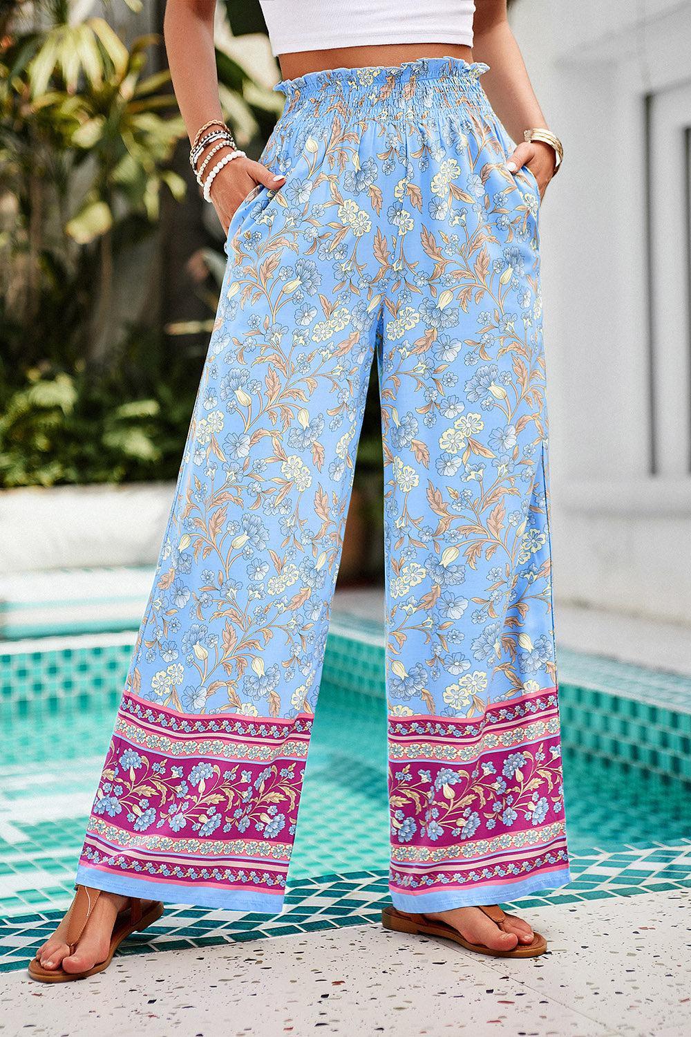 a woman standing in front of a pool wearing wide legged pants