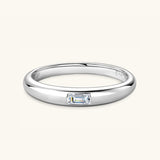a white gold ring with a baguette cut diamond