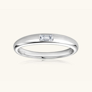a white gold ring with a baguette cut diamond