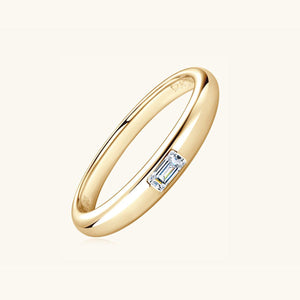 a yellow gold ring with a baguette cut diamond