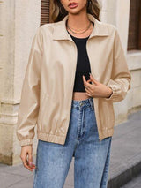 a woman wearing a tan jacket and jeans