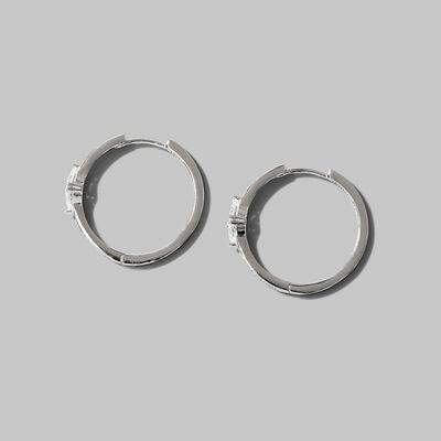 a pair of silver hoop earrings on a gray background