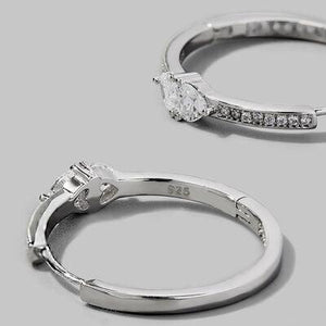 a pair of diamond engagement rings on a gray background