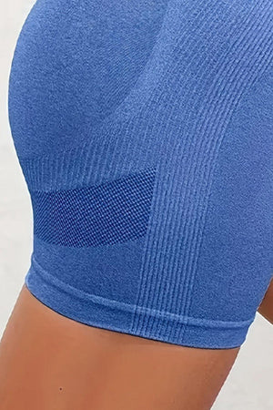 a close up of a person wearing a blue sports bra